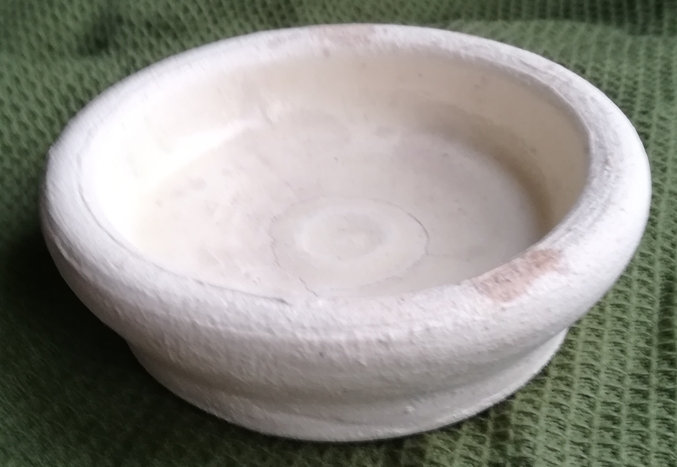 a picture of a small shallow stained white ceramic bowl